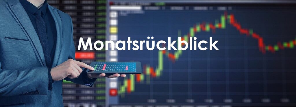 Person in Anzug hält ein Tablet mit Marktübersicht, im Hintergrund unscharfe Finanzcharts mit steigenden und fallenden Kursen sowie dem Wort „Monatsrückblick“ zentral im Bild.